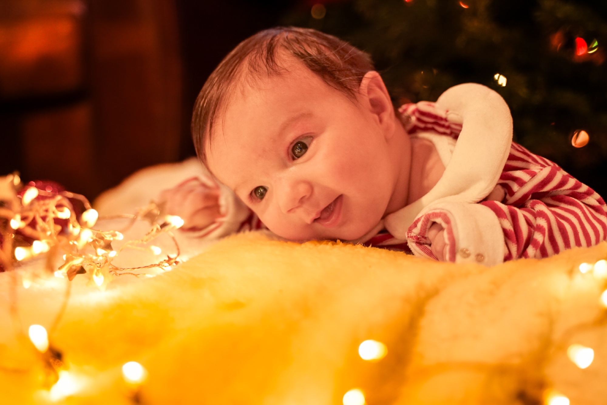 Tender newborn moment in warm festive light